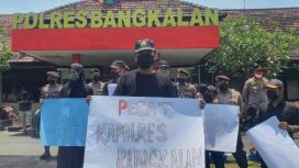 Salah satu demonstran membentangkan poster bertulisan